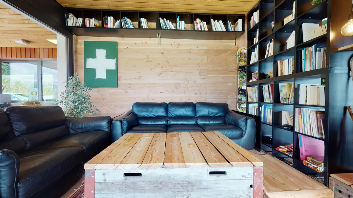 Le coin bibliothèque avec canapés en cuir et jeux de société