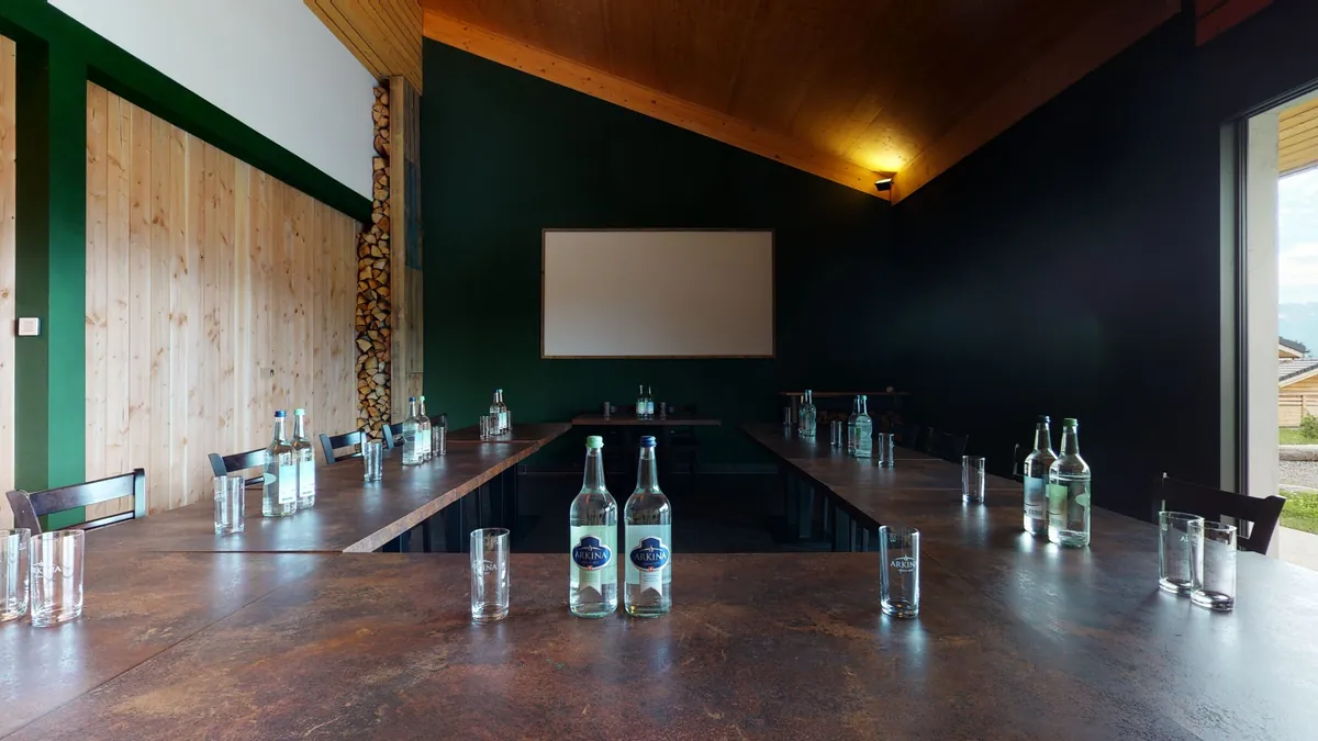 La salle privative en configuration séminaire, avec écran de projection