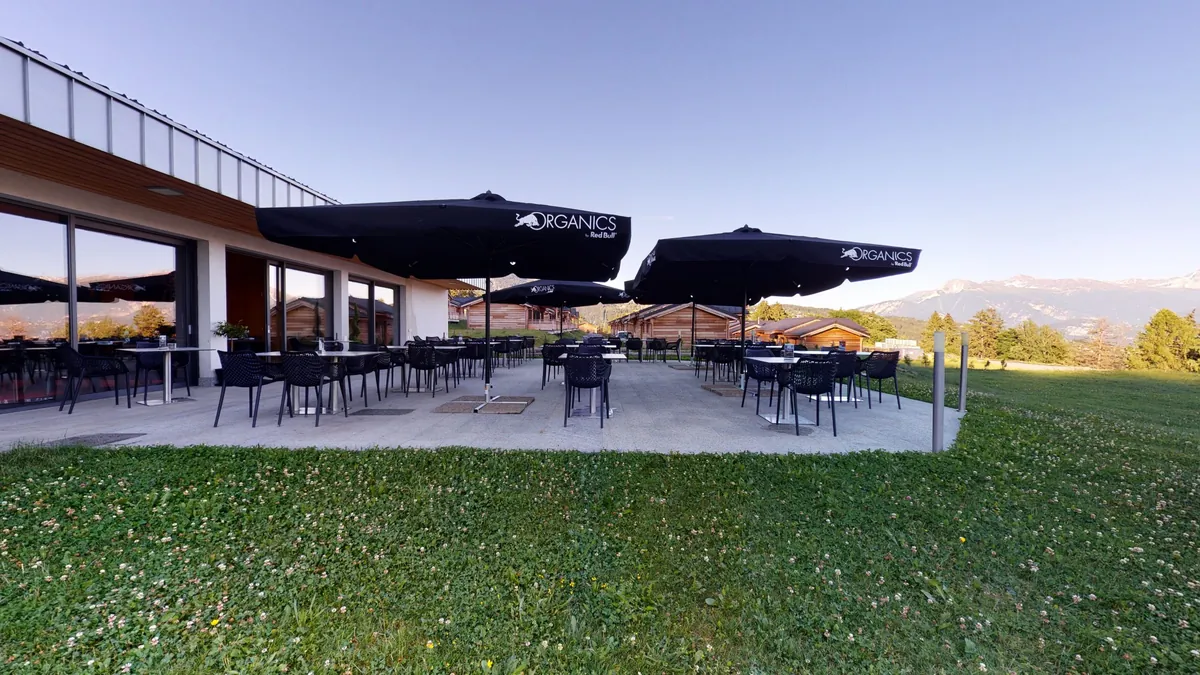 La terrasse du restaurant Woodland Village au crépuscule, face aux Alpes valaisannes